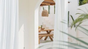 An interior space with a wooden table, a hanging light fixture, and a staircase leading to an upper level. - Mazari Villas (Bali)
