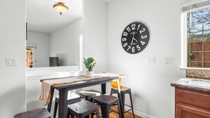 A dining area with a table, chairs, and a wall clock. - Walk to Downtown Paso & Sip Local Wine Under the Stars Casa Robles by Avantstay (Paso Robles)