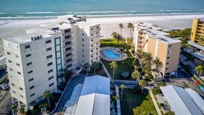 A beachfront hotel with multiple buildings, a swimming pool, and a beach view. - Tranquil villa with private beach, 2br/2ba 3 pools, complex on beach!! Patio (Sarasota)