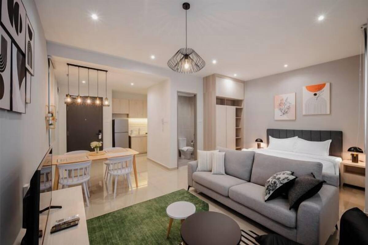 Een moderne hotelkamer met een bank, een zithoek, een keuken en een badkamer.
