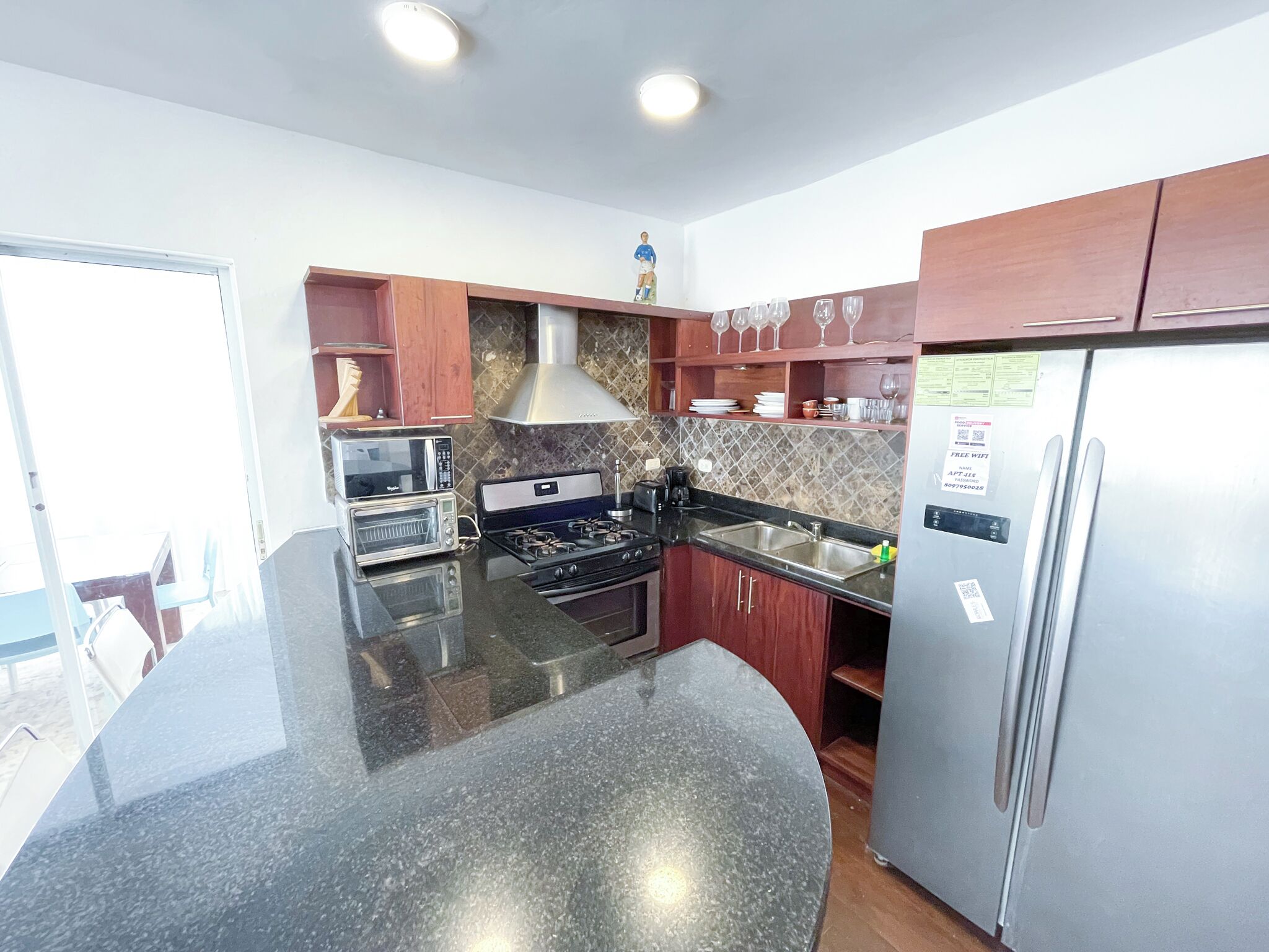 A modern kitchen with granite countertops, stainless steel appliances, and wooden cabinets.