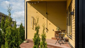A wooden house with a porch, a table, and chairs.