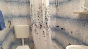 Une salle de bain avec des toilettes, une baignoire et un lavabo.