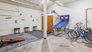 Ein Raum mit einem Basketballkorb, einer Bank und Fahrrädern.