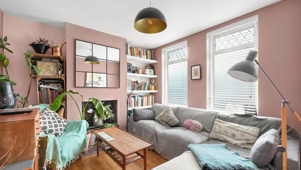 Ein gemütliches Wohnzimmer mit Sofa, Couchtisch, Bücherregal und Kamin.