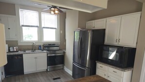 A kitchen with white cabinets, stainless steel appliances, a wooden countertop, and a window with blinds. - Cozy 3 bedroom Farmhouse in Delaware Ohio, On the Golf Course. Near OWU! (Delaware)