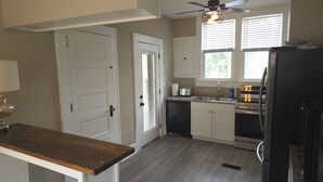 A kitchen with white cabinets, a wooden countertop, a ceiling fan, and a window with blinds. - Cozy 3 bedroom Farmhouse in Delaware Ohio, On the Golf Course. Near OWU! (Delaware)