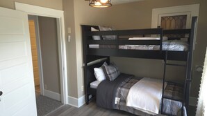 A bunk bed room with a ceiling fan and a door leading to another room. - Cozy 3 bedroom Farmhouse in Delaware Ohio, On the Golf Course. Near OWU! (Delaware)