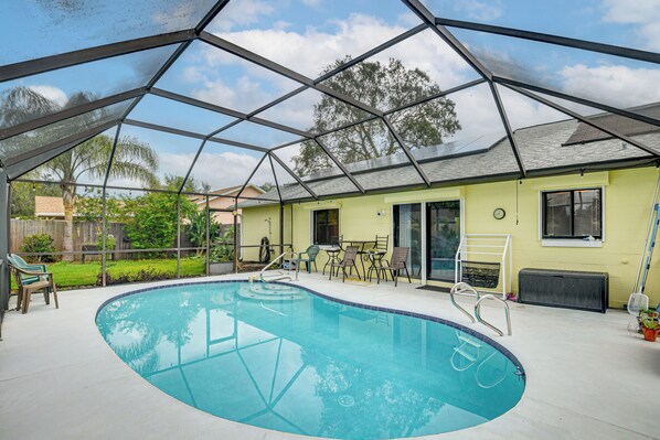 A covered outdoor swimming pool with a clear roof, surrounded by lounge chairs and a patio area. - 7 Mi to Beach! Poolside Oasis in Port Orange (Port Orange)