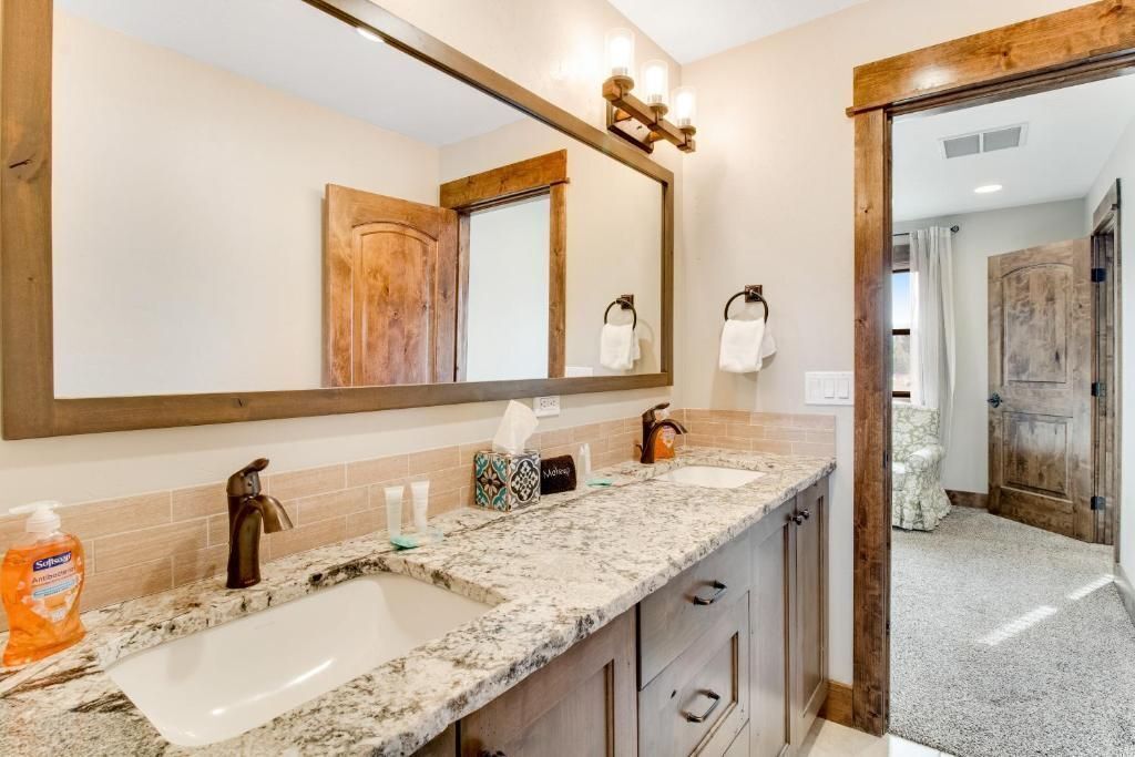 Une salle de bain avec un grand miroir, un lavabo et un porte-serviettes.