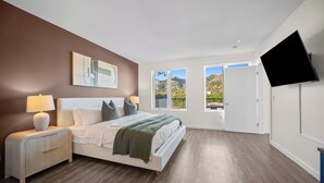 A bedroom with a bed, bedside table, lamp, and a TV mounted on the wall. - The Jade Hill' Luxurious Penthouse Two floors Hollywood Hills Pool, Gym, Jacuzzi (Los Angeles)