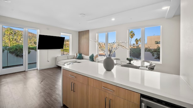 A modern kitchen with a large island, sliding glass doors, and a flat-screen TV. - The Jade Hill' Luxurious Penthouse Two floors Hollywood Hills Pool, Gym, Jacuzzi (Los Angeles)