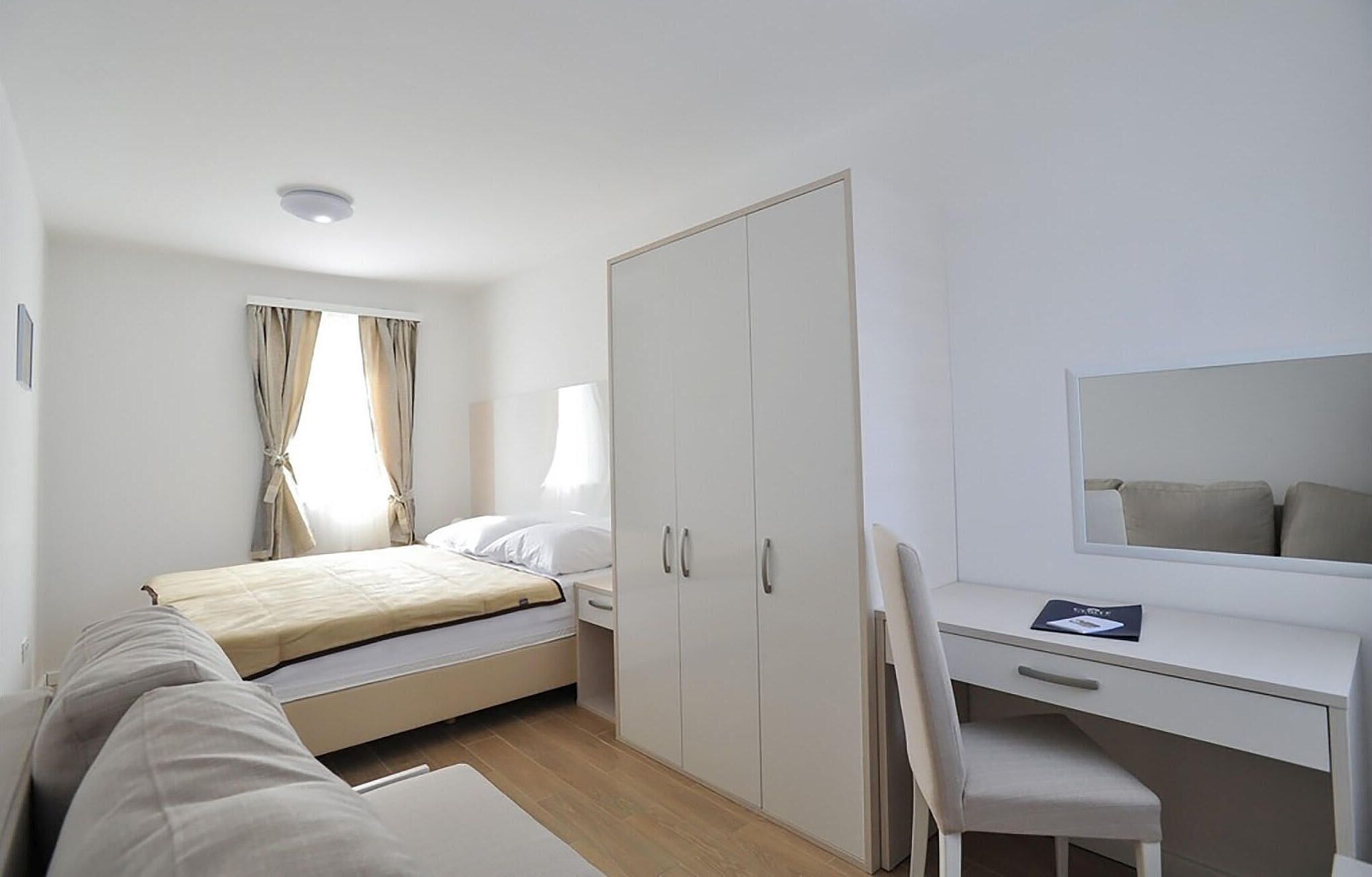 Une chambre d’hôtel moderne équipée d’un lit, d’un bureau, d’une chaise et d’une armoire.