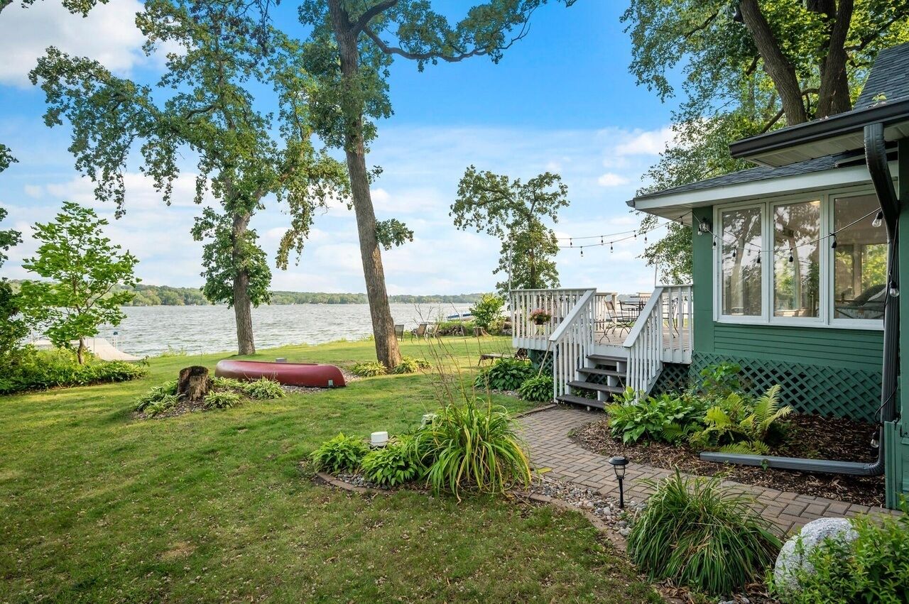 Une propriété située au bord du lac, dotée d’un porche abrité, d’une pelouse verdoyante et d’une vue sur le lac.