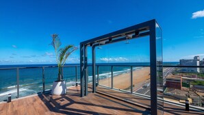 Un balcon moderne offrant une vue sur l’océan et le paysage urbain.