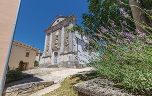 Une église historique dotée d’un clocher, d’un escalier en pierre menant à l’entrée et d’un jardin agrémenté de lavande.