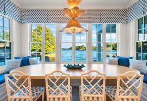 A dining area with a round table, four chairs, and a large window with a view of a body of water. - Lakeside Luxury w/Private Heated Pool, Sleeps 15 (Hot Springs)