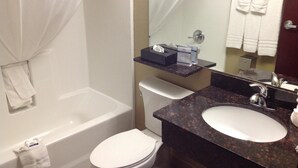 Une salle de bain avec une baignoire, des toilettes et un lavabo avec un miroir.
