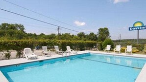 A swimming pool with lounge chairs and a Days Inn sign. - Red Roof Inn Rockingham (Rockingham)