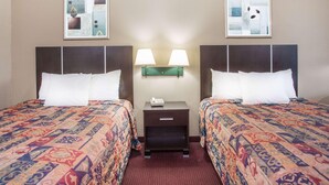 A hotel room with two beds, a nightstand with a lamp, and two framed pictures on the wall. - Red Roof Inn Rockingham (Rockingham)