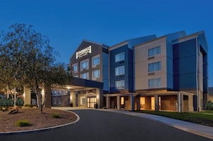 Un hotel Staybridge con un diseño moderno, que cuenta con varios pisos y una entrada bien iluminada.