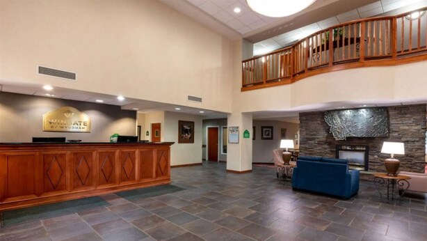 A spacious lobby with a reception desk, a blue sofa, and a stone fireplace.