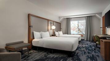 A hotel room with two beds, a desk, a chair, and a television.