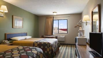 A hotel room with two beds, a desk, a TV, and a window with a view.