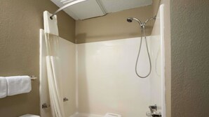 A small, enclosed shower area with a white shower seat and a handheld showerhead. - Super 8 by Wyndham Blackwell (Blackwell)