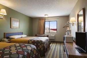 Quarto de hotel com duas camas, uma escrivaninha, televisão, janela com vista e iluminação no teto.