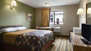 A hotel room with a bed, a desk, a television, and a window with curtains. - Super 8 by Wyndham Blackwell (Blackwell)