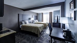 Een hotelkamer met twee bedden, een bureau en een stoel.
