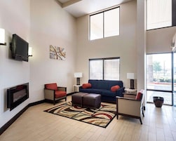 A spacious living room with a fireplace, a large window, and a blue sofa.
