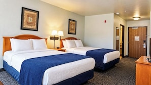 A hotel room with two beds, a desk, and a door. - Magnuson Grand Pikes Peak (Manitou Springs)