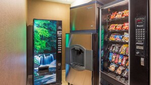 Una máquina expendedora con una pantalla tipo cascada y una variedad de aperitivos.