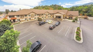 A hotel with a parking lot, multiple buildings, and a mountainous backdrop. - Magnuson Grand Pikes Peak (Manitou Springs)