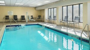 An indoor swimming pool with clear water, a lifeguard chair, and a sign on the wall. - Fairfield by Marriott Inn & Suites Rome NY (Rome)
