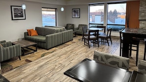 A modern interior with a sofa, chairs, a dining table, and large windows offering a view. - Holiday Inn Express And Suite Eden Prairie Minneapolis (Eden Prairie)