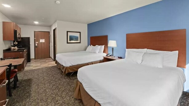A hotel room with two beds, a desk, a chair, a lamp, and a picture on the wall. - Mainstay Suites Spokane Valley, WA (Spokane Valley)