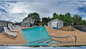 A swimming pool with lounge chairs, a small building, and a fenced area. - Red Roof Inn Jasper (Jasper)