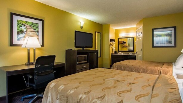 A hotel room with two beds, a desk with a chair, a television, and a mirror. - Red Roof Inn Jasper (Jasper)