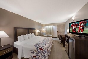 A hotel room with a large bed, a desk, a television, and a window with curtains. - Red Roof Inn Jasper (Jasper)
