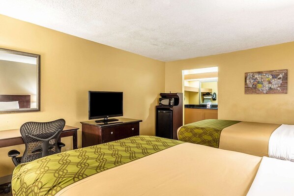 A hotel room with two beds, a desk with a television, a chair, a refrigerator, and a mirror. - Econo Lodge Moss Point - Pascagoula (Moss Point)