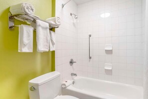 A bathroom with a white bathtub, a toilet, and a shower. - Econo Lodge Moss Point - Pascagoula (Moss Point)