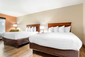 A hotel room with two beds, a green chair, and a window. - Econo Lodge Moss Point - Pascagoula (Moss Point)