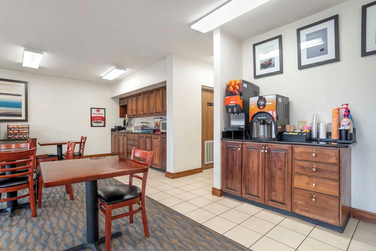 A hotel room with a dining area, kitchenette, and a coffee station.