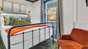 A bedroom with a bed, a chair, a window, and a ceiling fan. - 1 mile Pkwy~Single level ~ Sauna, Outdoor Movies (Pigeon Forge)
