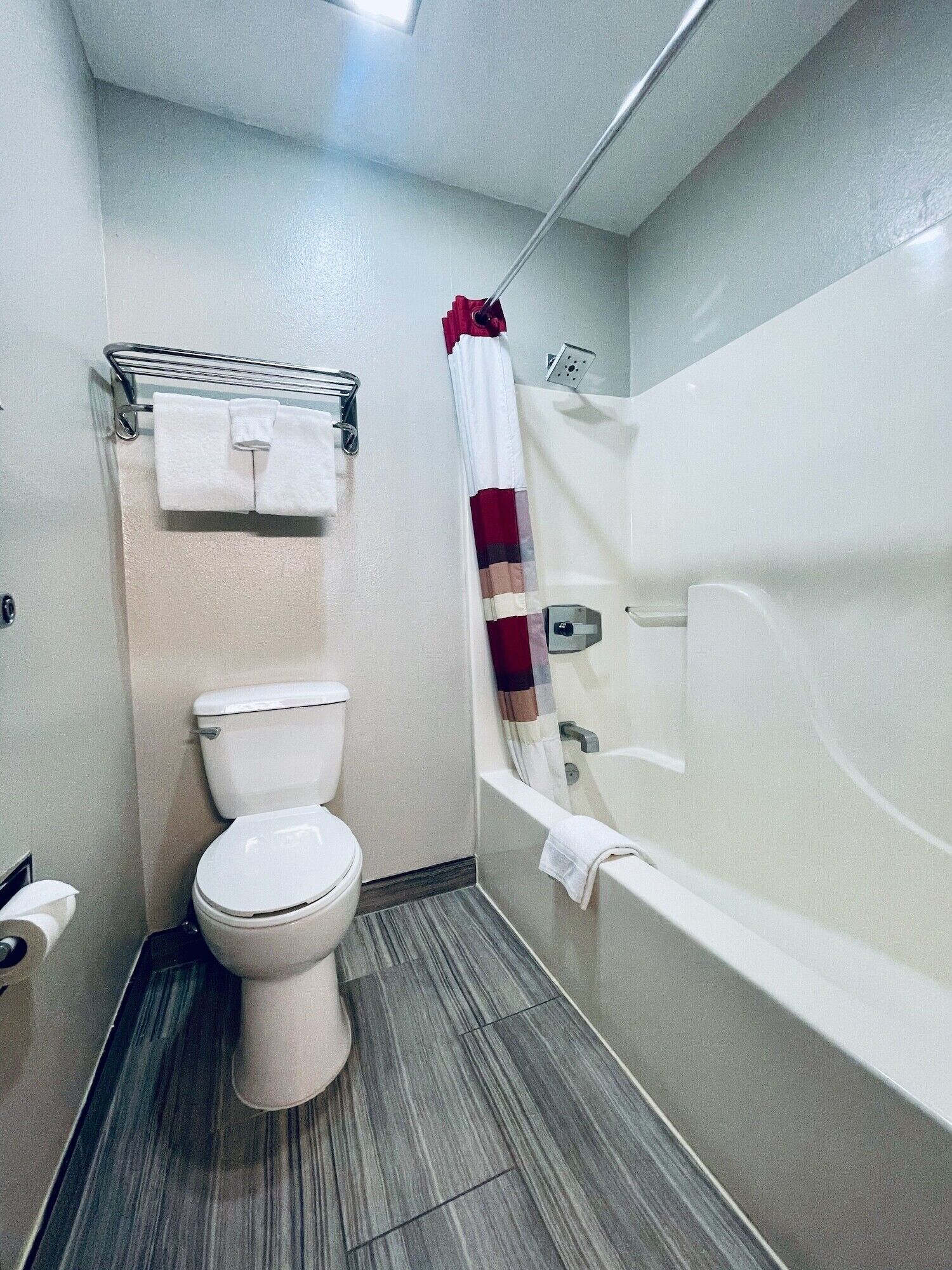 A bathroom with a toilet, a bathtub, and a shower curtain.
