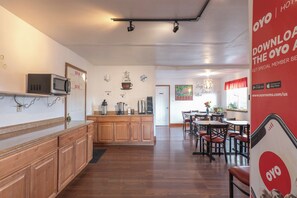 A hotel kitchen with wooden cabinets, a microwave, and a coffee station. - Travelodge by Wyndham Chehalis (Chehalis)