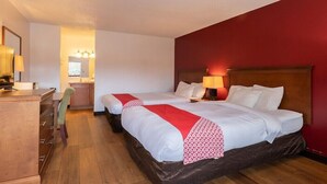 Une chambre d’hôtel avec deux lits, un bureau et une chaise.